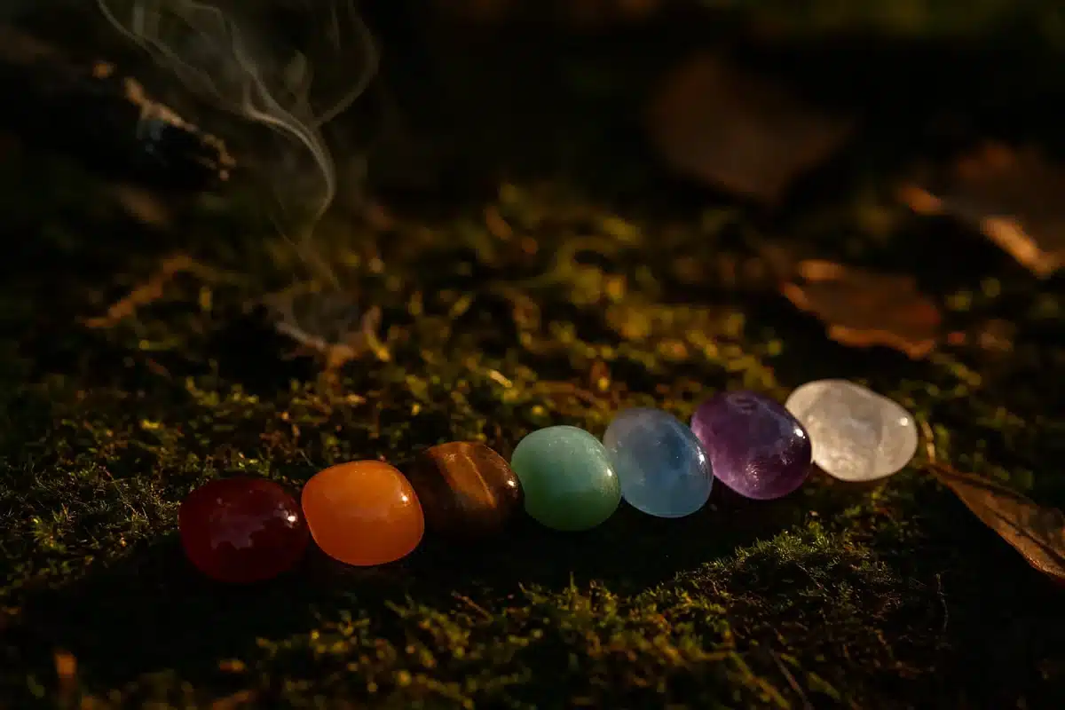 سنگ هفت چاکرا صیقلی‌شده و براق بر بستر طبیعی خزه و خاک