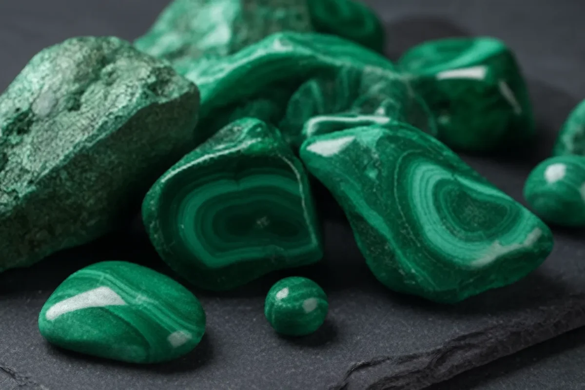 نمای نزدیک از سنگ‌های طبیعی سبز با رگه‌های حلقه‌ای، نمایش‌دهنده خواص سنگ مالاکیت